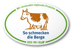 On reconnaît un refuge "  So-schmecken-die-Berge " à son enseigne portant le motif d'une vache et à la carte des menus sur laquelle se distinguent les offres correspondantes.