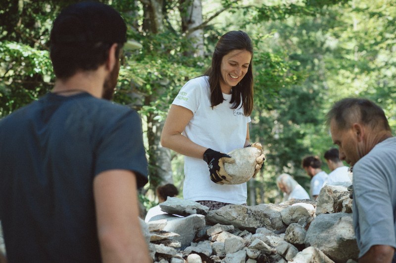 Les jeunes participant·e·s réparent des murs en pierre sèche dans l’atelier © Natalia Polonskaia